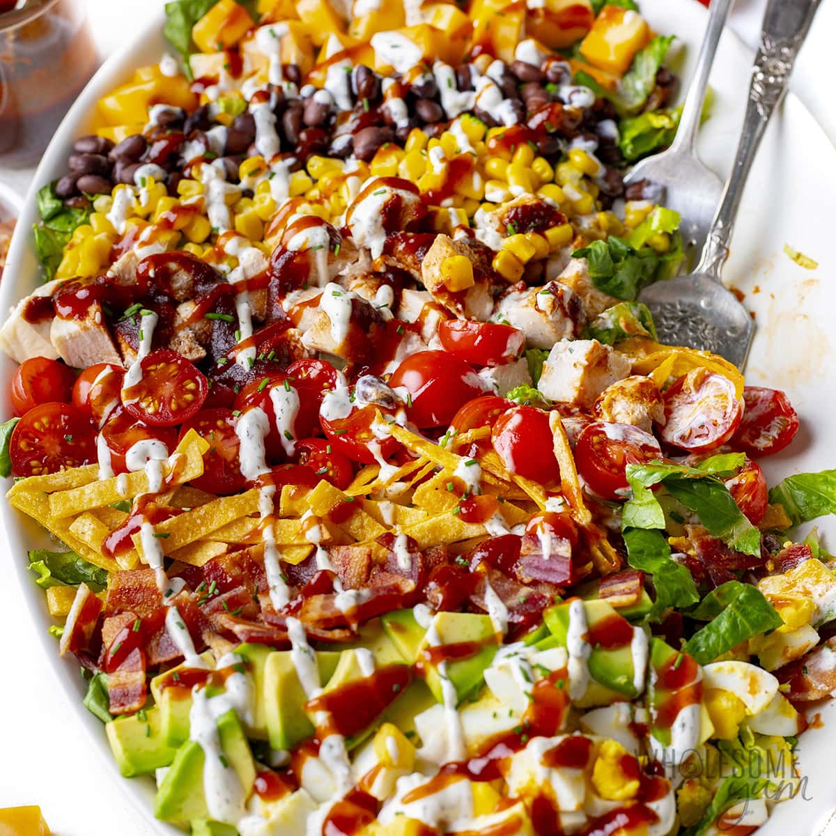 BBQ chicken salad drizzled with dressing.