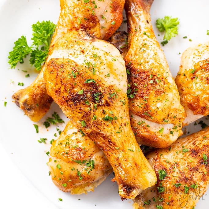 Plate of baked chicken leg drumsticks