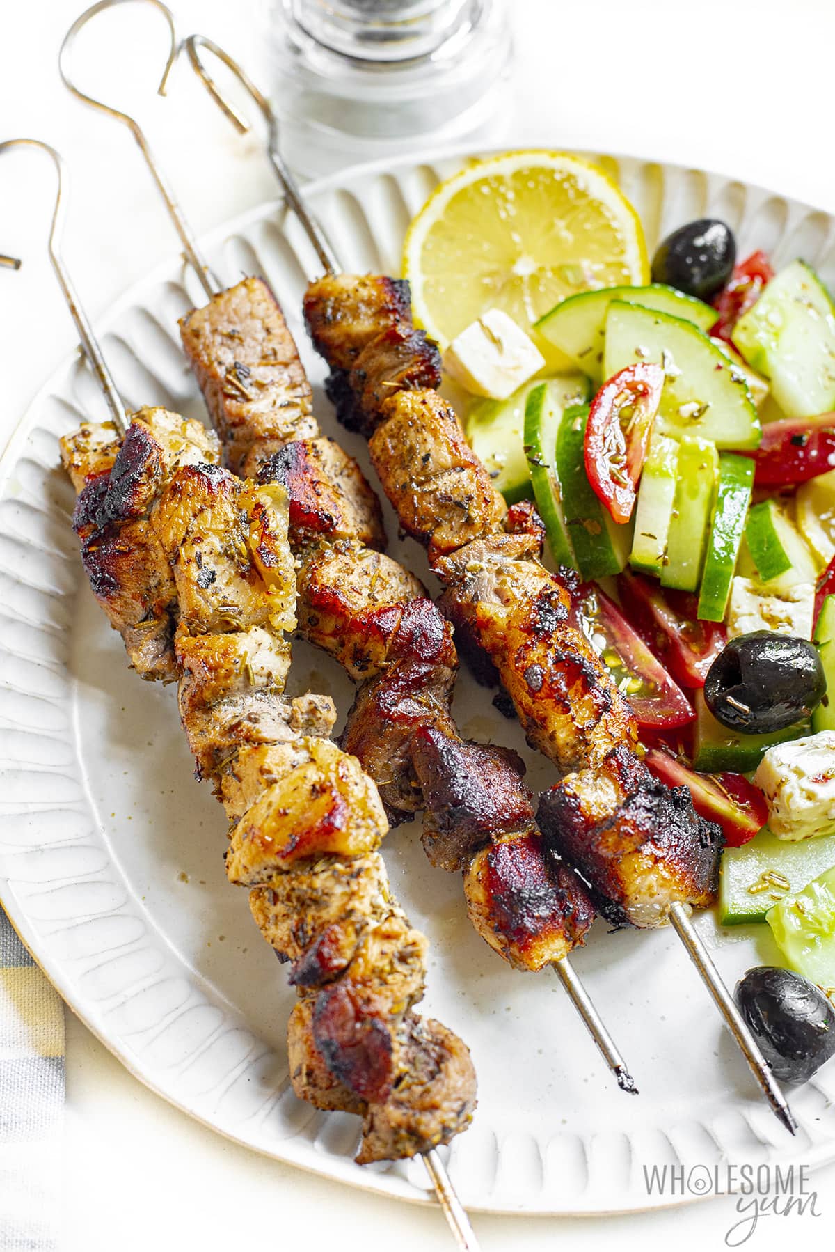 Finished Greek souvlaki with salad on a plate.