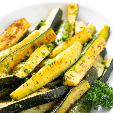 Oven roasted zucchini recipe in a white dish.