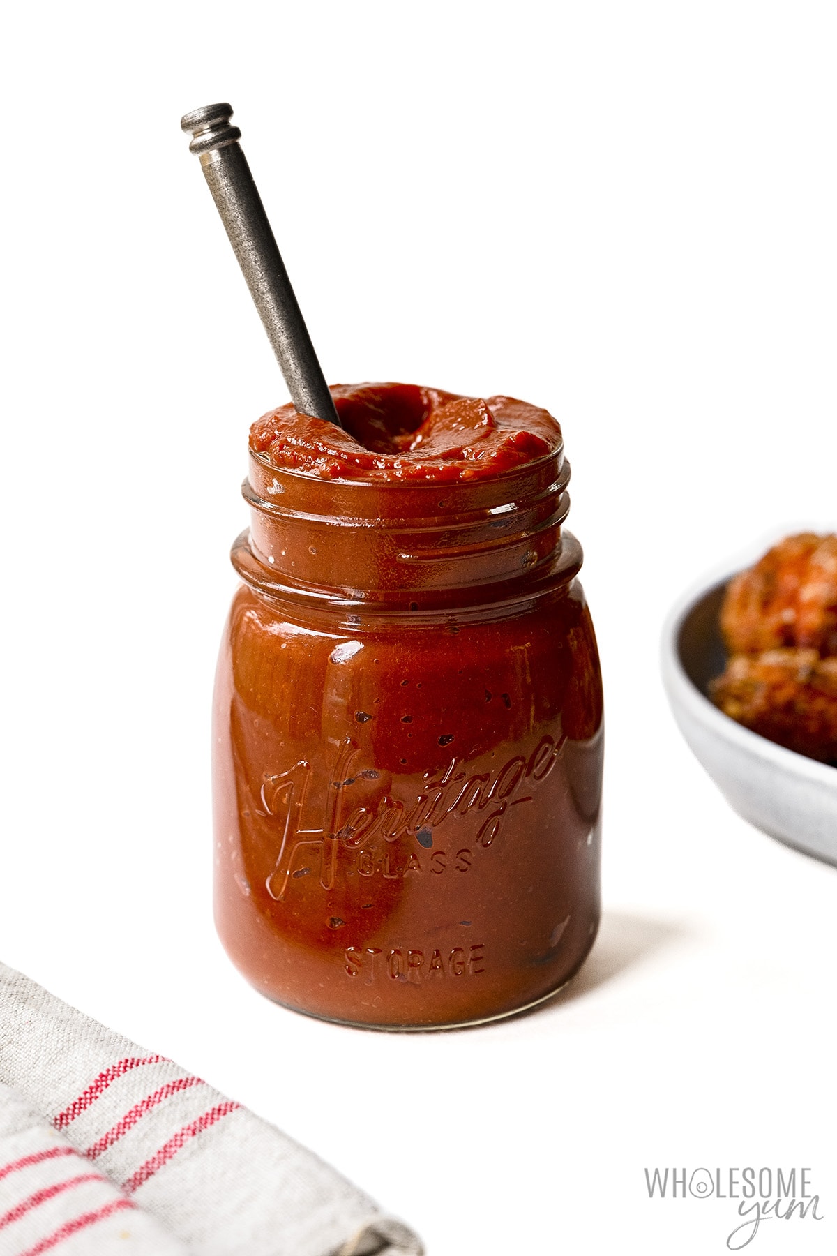 Sugar free BBQ sauce in a mason jar with a spoon.