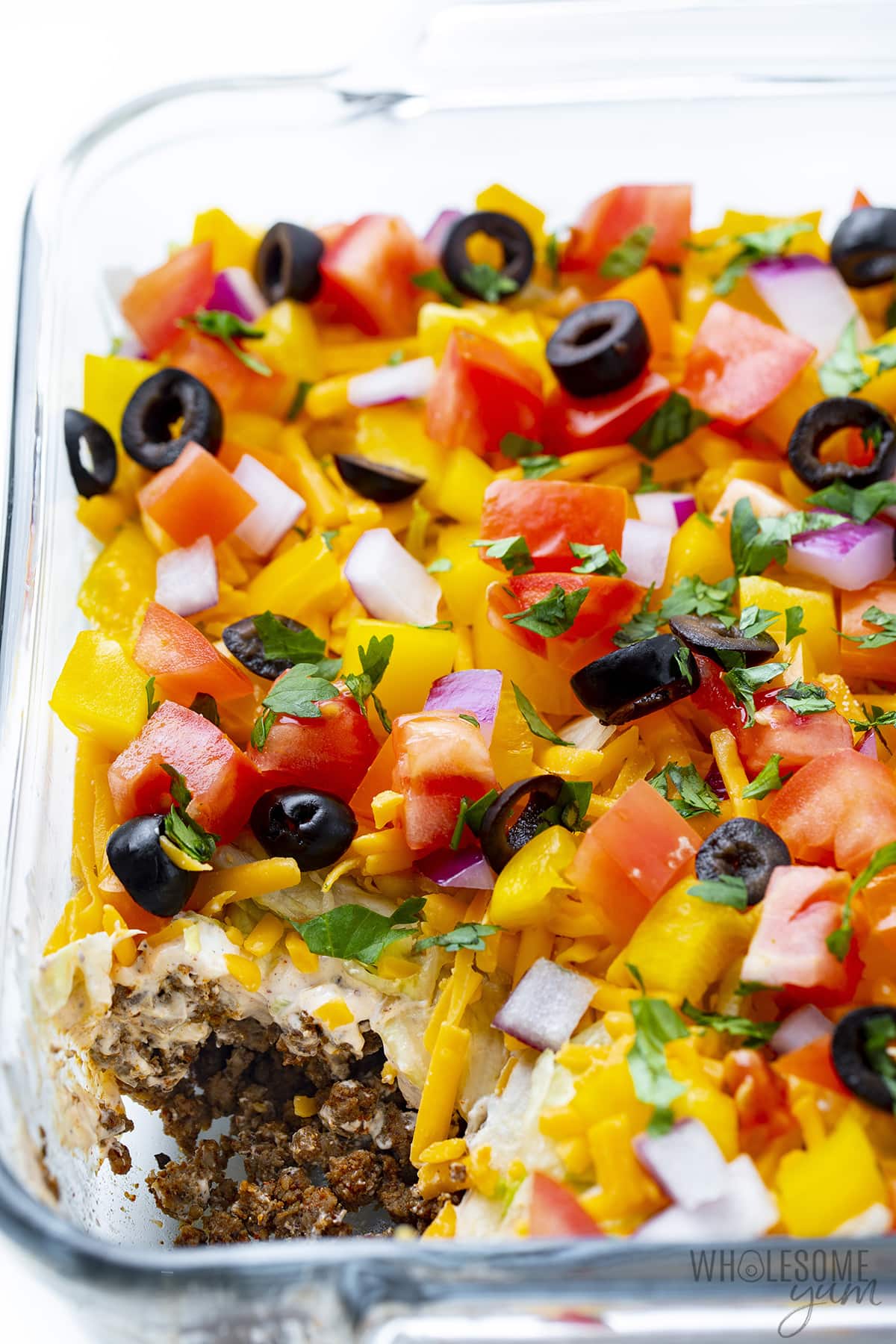Taco dip in a clear baking dish.